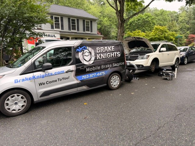 Brake Knights technician servicing a vehicle in a customer's driveway