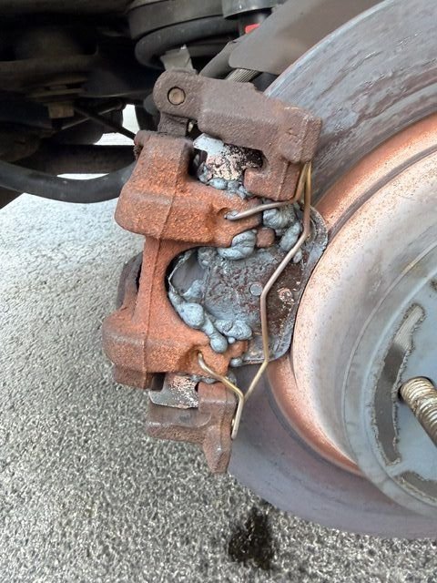 Seized caliper with overheated and melted pads against rotor